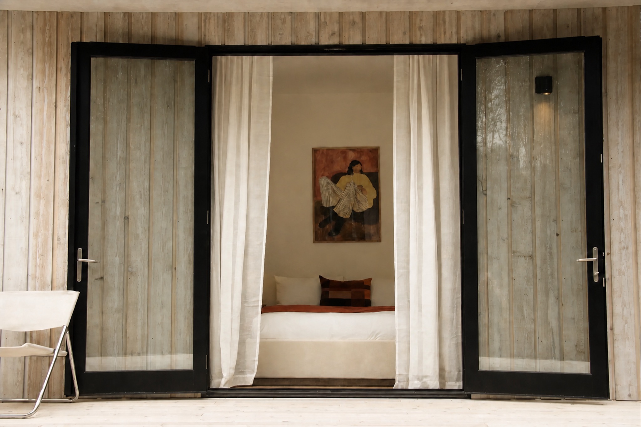 Bedroom seen through open glass doors from the Norma cabin deck
