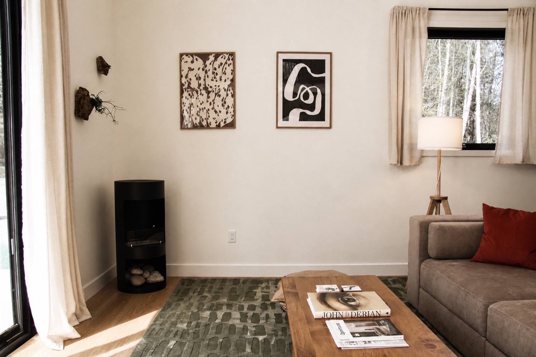 Norma cabin living room with a fireplace, sofa, and forest views