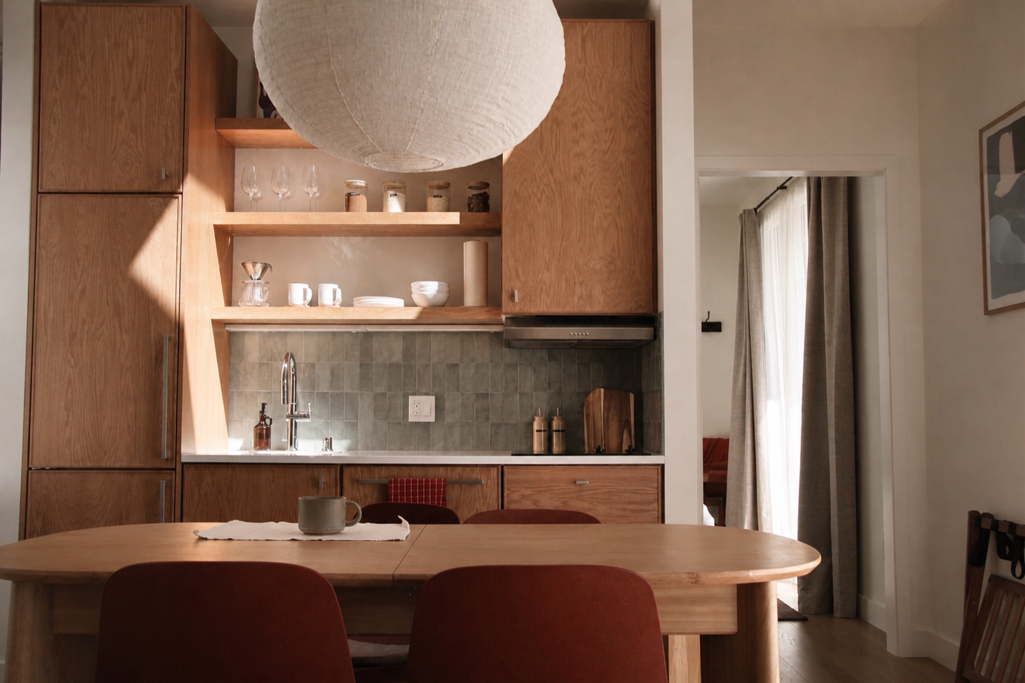 Norma cabin kitchen with wood cabinets, tiled backsplash, and dining table