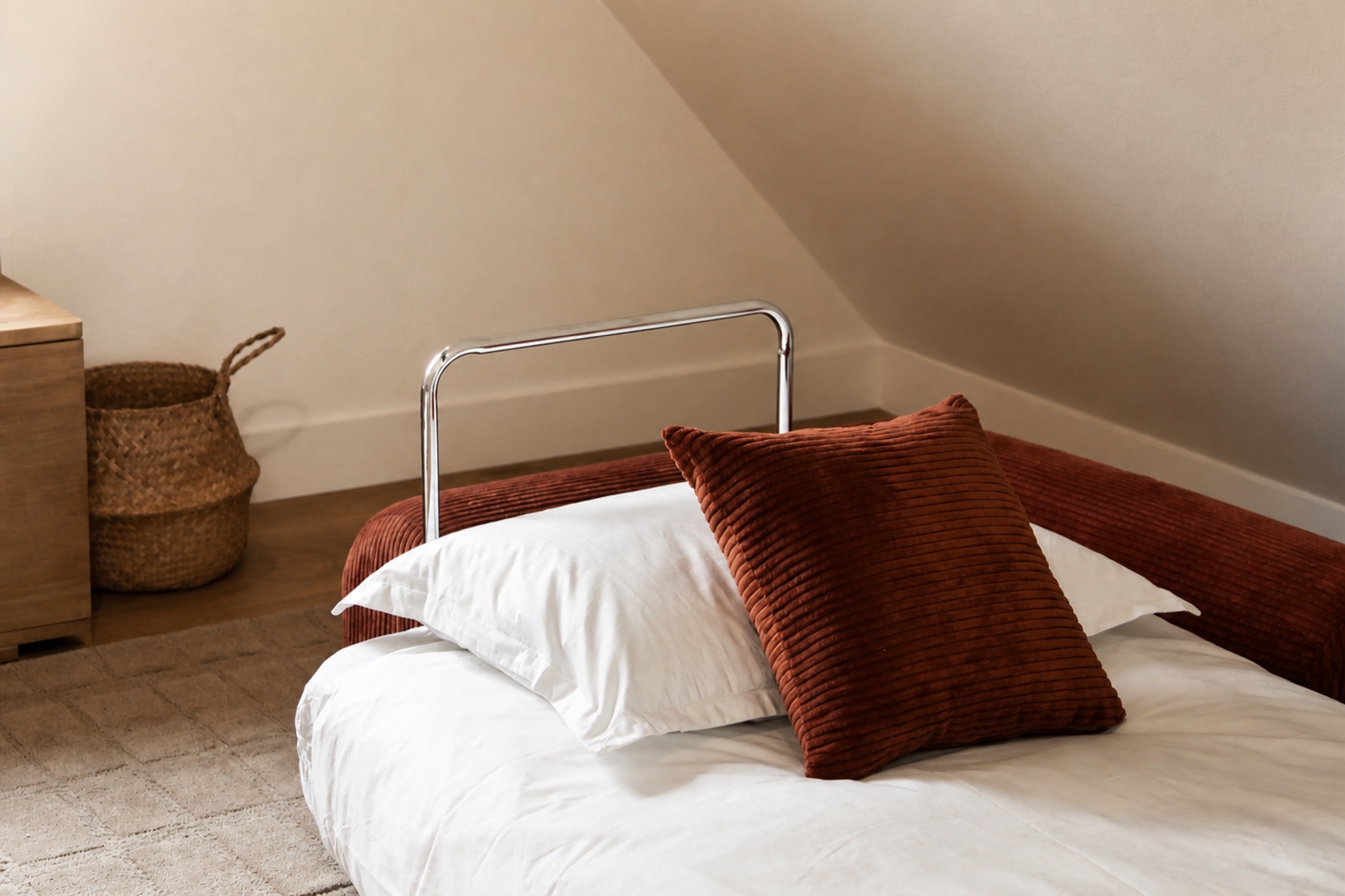 White bedding and rust-colored cushions in the Norma cabin loft